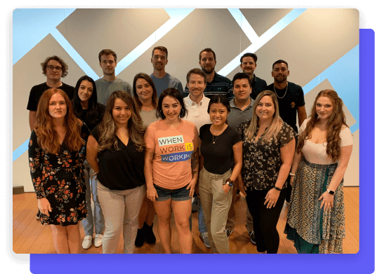 Team members posing together in a group photo against a geometric-patterned wall.