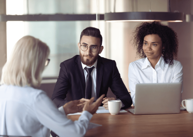 Interview panel with a man and woman listening to a candidate.