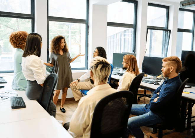 Group of diverse coworkers having a discussion in an open office space.