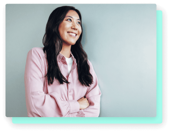 Confident woman smiling with arms crossed, looking off to the side.